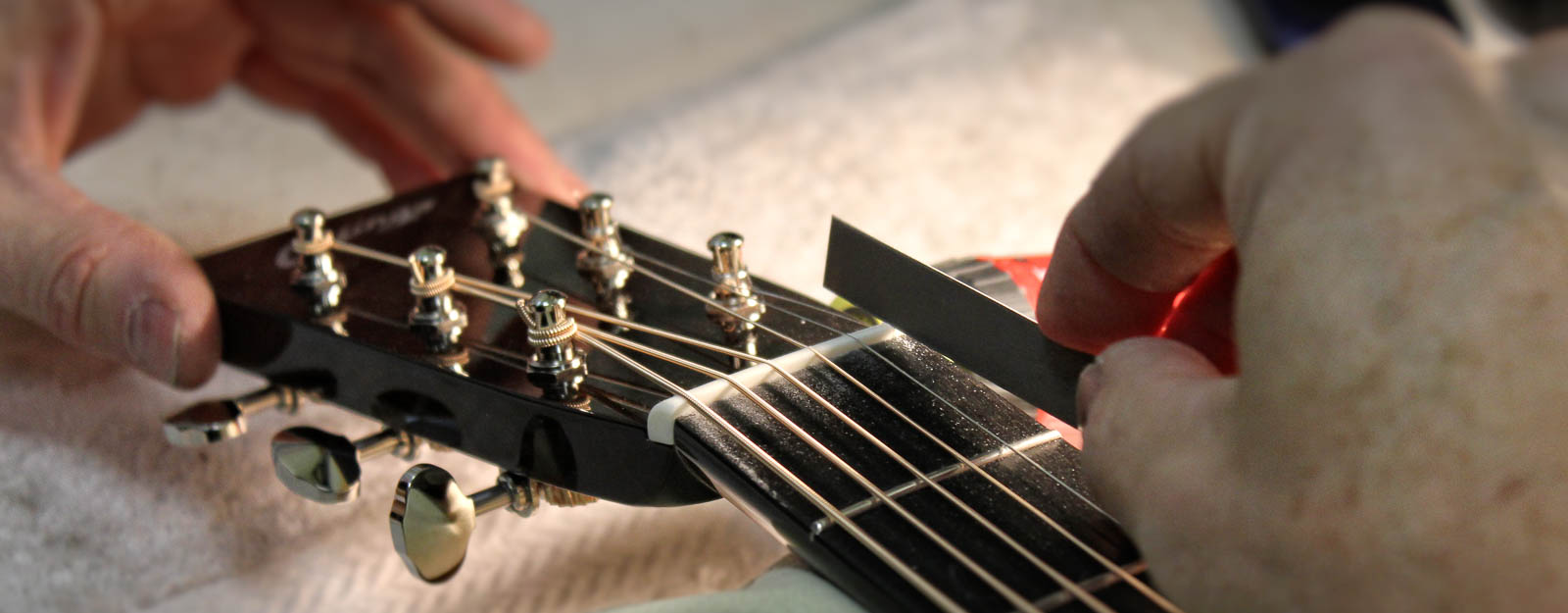 Luthier Adjusting Acoustic Guitar Nut Slots